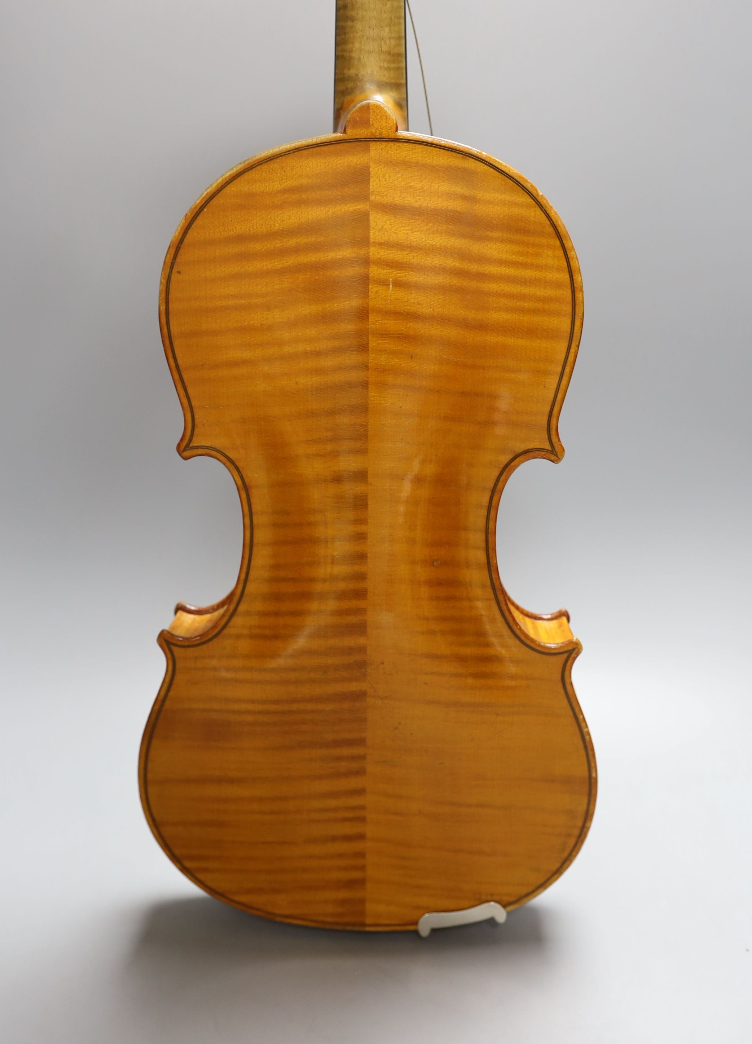 A 20th century violin in case with two bows, length of back 35.5cm